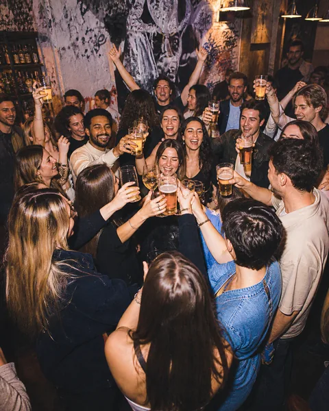 Groupe en soirée qui trinque dans un bar